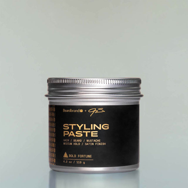 A container of Bold Fortune Styling Paste against a grey background.