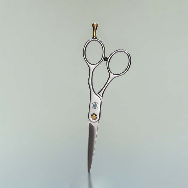 A pair of Beardbrand Beard Trimming Scissors against a grey background.