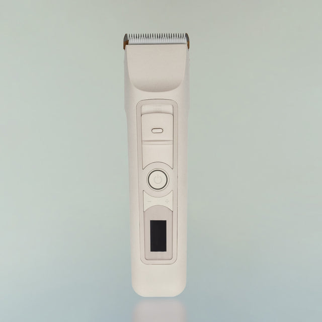 The Beardbrand Utility Trimmer with a sleek design. It features a metal trimming head, a power button, and a small digital display on its body.