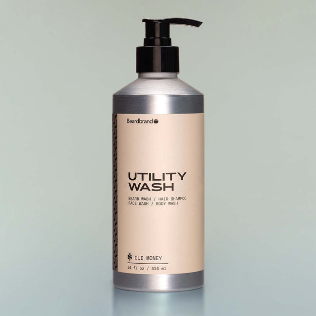 A bottle of Old Money Utility Wash with a pump dispenser against a grey background.